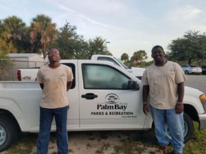Two brothers standing next to a white truck.