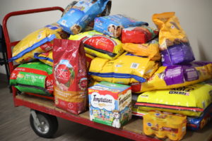 A pile of animal food and toys loaded on a platform truck.