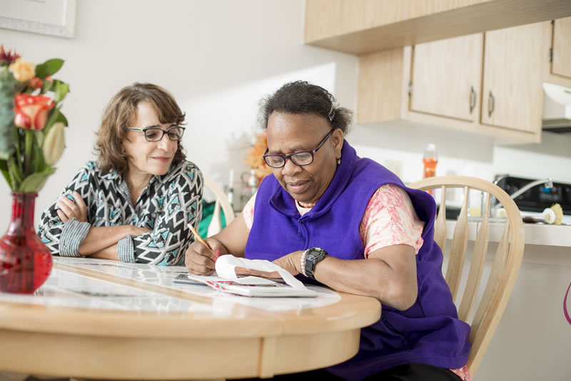 Female coach helping female participant with paperwork